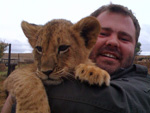 Man holding a lion cub on a Lion Park excursion in South Africa